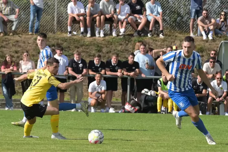 Hermersbergs Trainer Jens Mayer (im Hintergrund in der Mitte kniend) verfolgt gespannt, wie sein Spieler Jan Lelle (links) den G