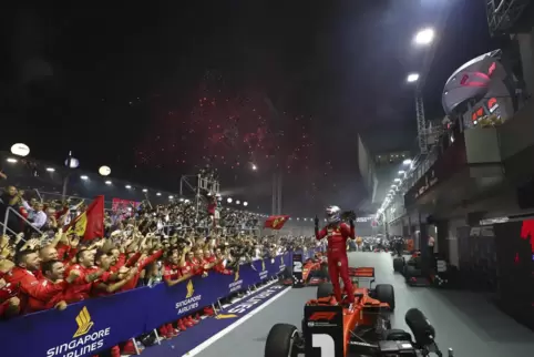 Der letzte seiner bislang fünf Erfolge in Singapur: Sebastian Vettel nach dem Rennen auf seinem Ferrari-Boliden stehend.