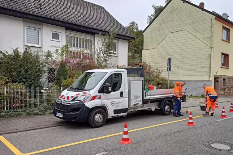 UBZ-Mitarbeiter entfernen am Mittwoch die gelben Parkbucht-Markierungen in der Altheimer Straße.