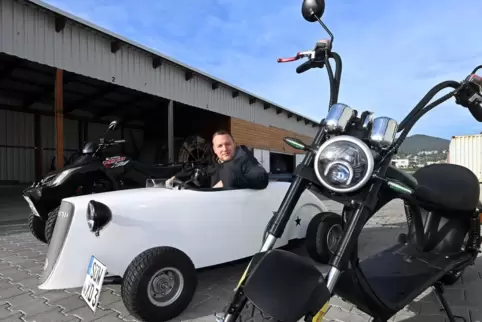 Marcel Baumann in einem „Hot Rod“, das an eine Seifenkiste erinnert, dahinter ein Quad, vorne ein Elektro-Chopper.