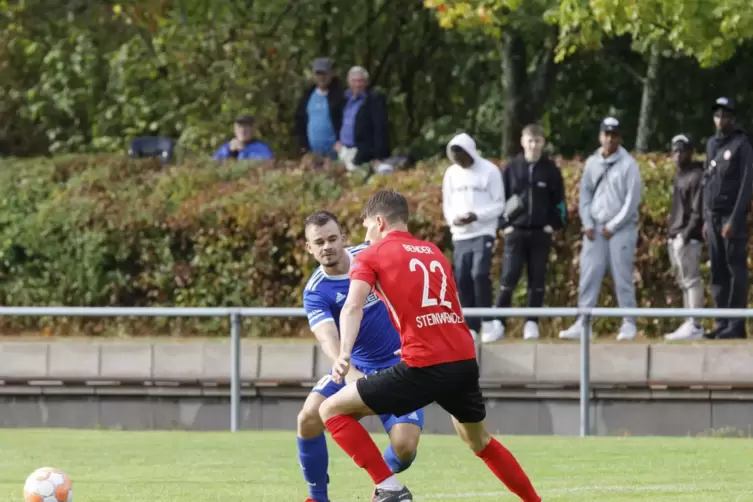 Zweikampf neben dem Ball: Lukas Krieg vom TuS Hohenecken (im blauen Trikot) und Daniel Bender (SV Steinwenden). Szene aus der Ve