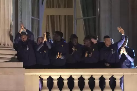 Die Spieler der französischen Nationalmannschaft winken vom Balkon des Hotels Crillon in Paris. 