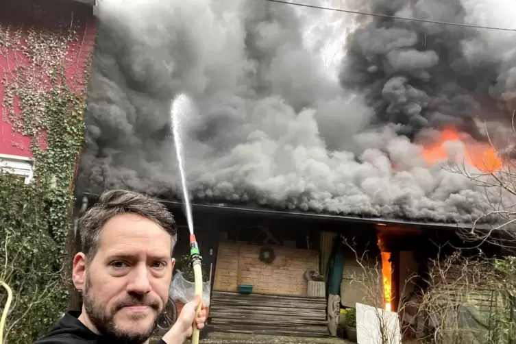 Mit einem Gartenschlauch versucht Alexander Wieser, das Feuer zu löschen. 