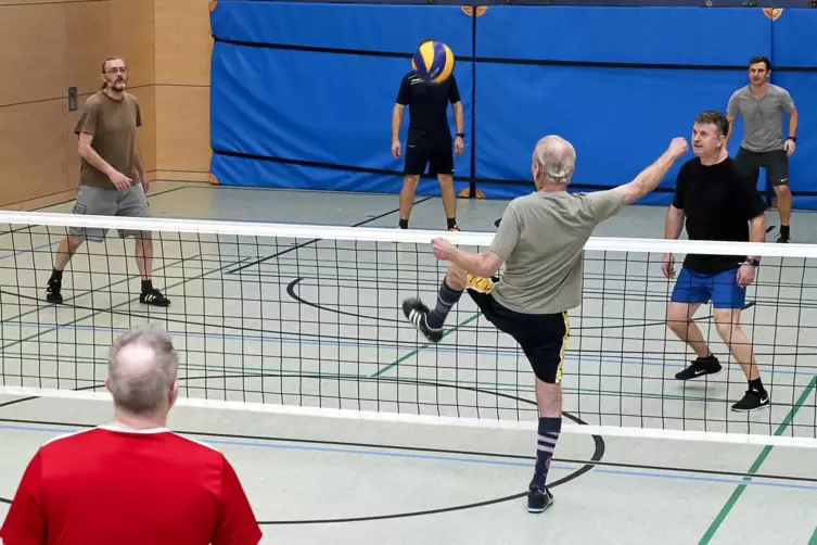 Fritz Schmidt (Mitte), Zweibrücker Fußball-Urgestein, spielt den Ball übers Netz, Teamkollege und Fußballtennis-Initiator Reiner