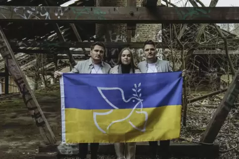 Bei den Dreharbeiten zum Musikvideo für „Somewhere Only We Know“: Die King-Zwillinge und Yasya Levchenko zeigen Flagge. 