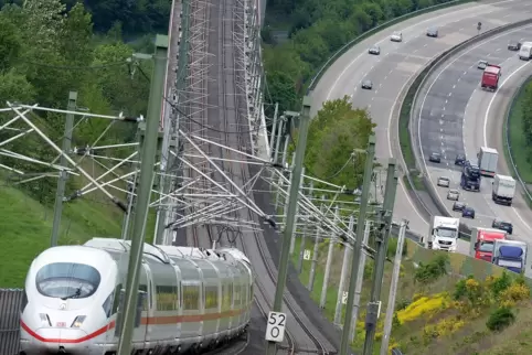 Ein ICE der Deutschen Bahn fährt auf der Hochgeschwindigkeitsstrecke zwischen Köln und Frankfurt am Main neben der Autobahn A3 ü