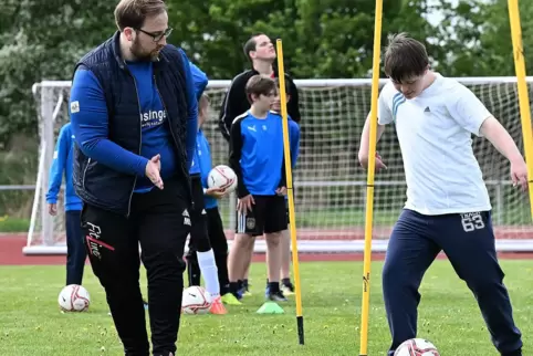 Slalomdribbeln: TSG-Trainer Marcel Schwarz (links) unterstützt hier einen Lebenshilfe-Fußballer.