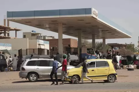 Menschen stehen an einer Tankstelle in Karthoum an, während das Geschützfeuer und der schwere Artilleriebeschuss anhalten.