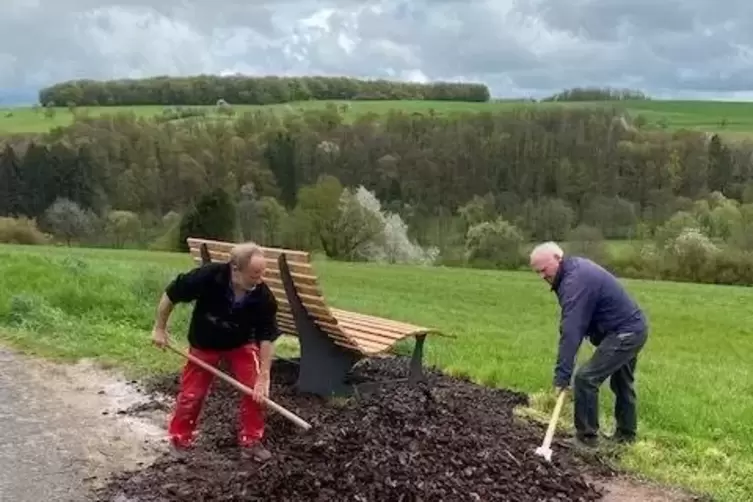 Herbert Beckmann (links ) und Otto Imhof umgeben die Bank in der Breitensteinstraße mit Rindenmulch.