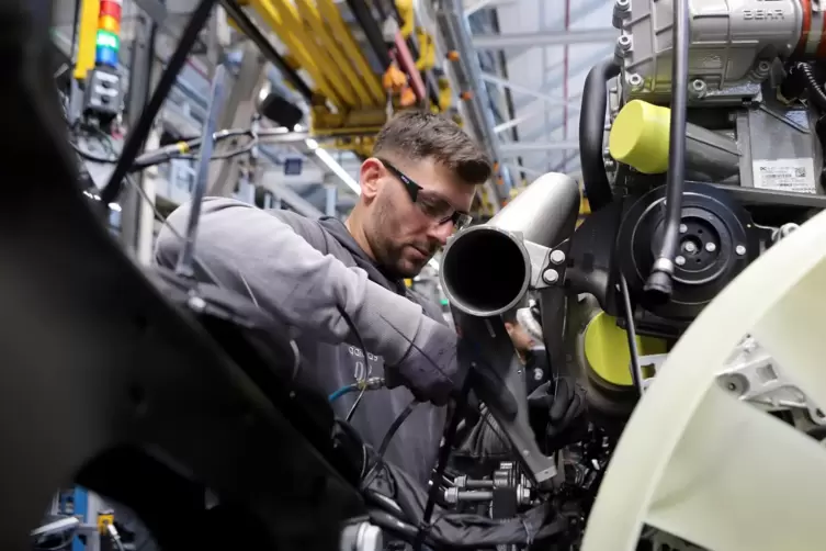 Die sogenannte Verlobung: Im Lkw-Werk im südpfälzischen Wörth setzt ein Mitarbeiter einen Motor in den Rahmen eines Lastwagens. 