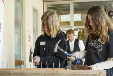 Selbst ausprobieren: Mia und Amy üben sich im Dachdeckerhandwerk beim Stand der Firma Walther.