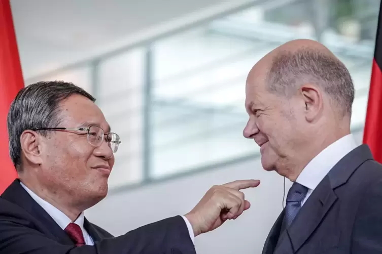 Höflicher Gast: Chinas Ministerpräsident Li Qiang erinnert Kanzler Olaf Scholz daran, den Ohrhörer abzulegen. 