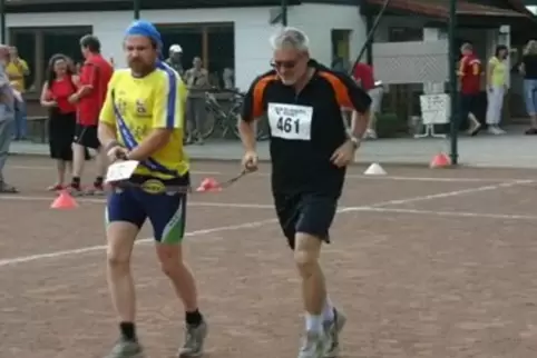 Werner Lang (rechts) begleitet den sehbehinderten Läufer 13 Kilometer lang mit einem Seil.