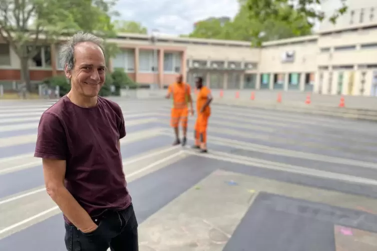 Daniel Baumann als Teil des Künstler-Duos L/B achtet darauf, dass das Streetpainting für den Karl-Kornmann-Platz von der Farbmar