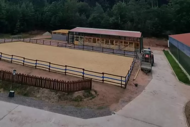 Reitplatz mit Stallungen im Hintergrund, rechts daneben die Reithalle an die sich das Restaurant anschließt. 