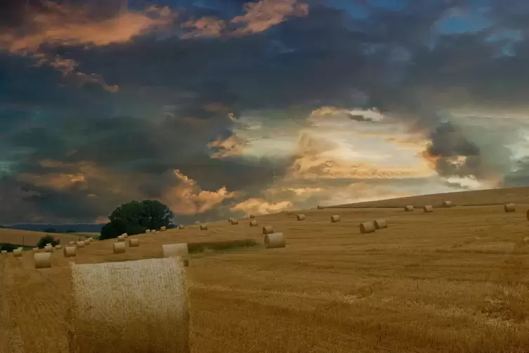 Leser Dieter Mannweiler aus Niederkirchen schreibt: Dramatische Wolkenbildung über einem Feld mit Strohballen bei Schneckenhause