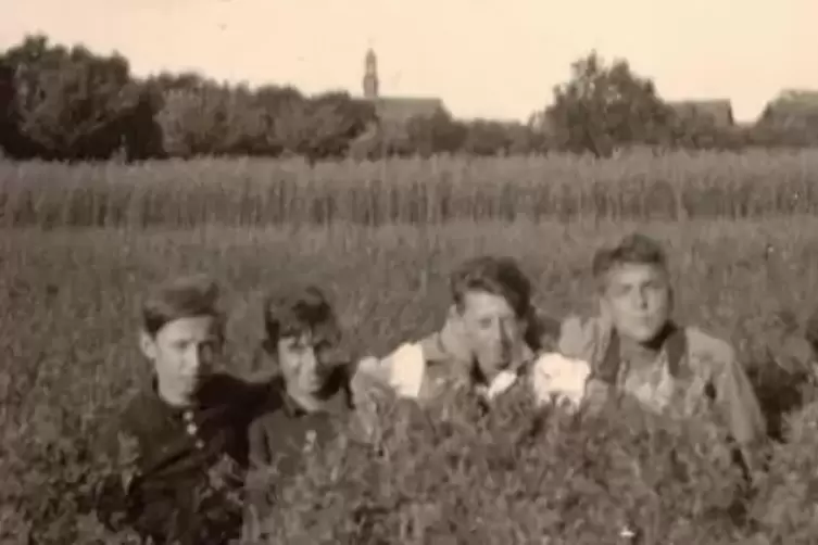 Kindheit 1939: Albert Emmerlingmit seinen Freunden und im Hintergrund die alte Leimersheimer Kirche.