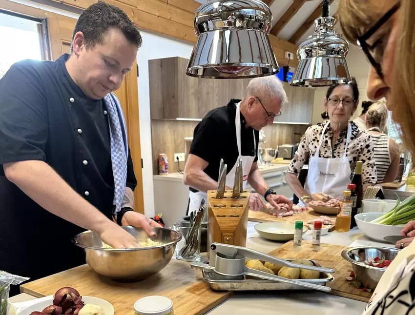 Bereitet mit seiner Gruppe das Hühnchen vor: Koch Alex Eva (li.).