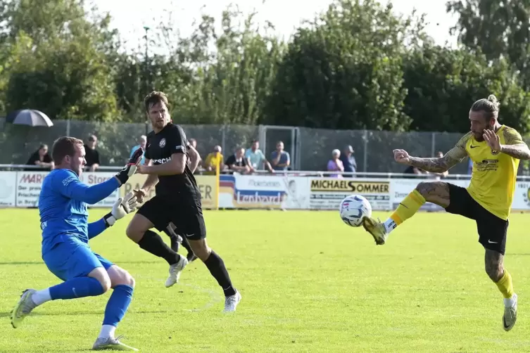 Der Hermersberger Patrick Freyer lupft an Steinwendens Keeper Daniel Lembach vorbei den Ball zum 4:2 ins Tor. In der Mitte beoba