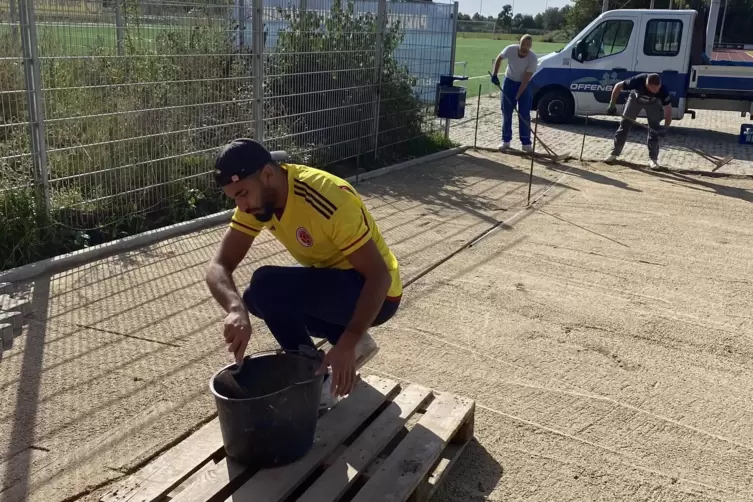 Fußballer Abu Benaouda legt die Steine, während im Hintergrund Robin Henz und Philipp Pertschy den Sand glätten.