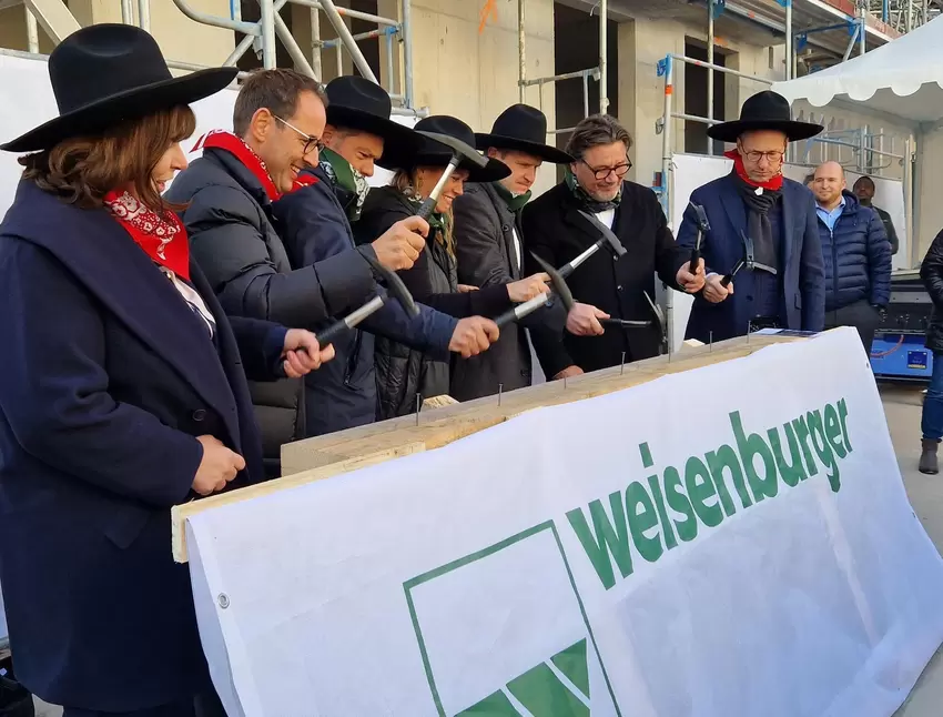 Symbolisch fürs Richtfest schlagen die Bauherren, der Architekt und Oberbürgermeisterin Jutta Steinruck Nägel in einen Balken.