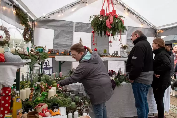 Die Marktbesucher nehmen interessiert das Angebot unter die Lupe.