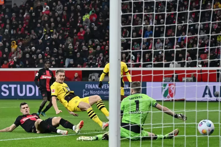  Julian Ryerson von Borussia Dortmund überwindet Bayer-Torhüter Lukas Hradecky.