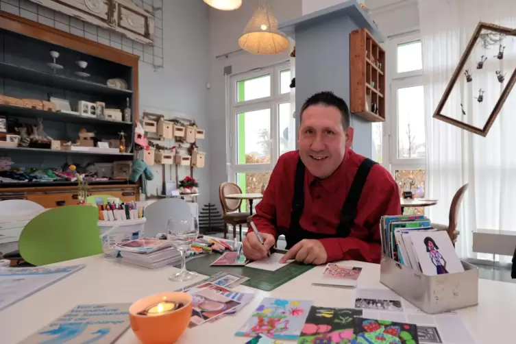 Jürgen Stenzel bemalt im Bistro Lebensreich der Lebenshilfe Grünstadt-Eisenberg Postkarten.