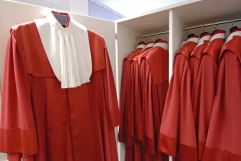 Die 16 Verfassungsrichterinnen und -richter tragen traditionell scharlachrote Roben mit weißem Jabot.