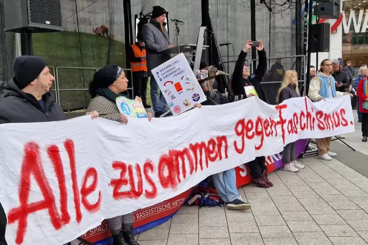 Plakat vor der Bühne am Berliner Platz. Am Mikro: Ibrahim Yetkin, stellvertretender Vorsitzender des Beirats für Migration und I