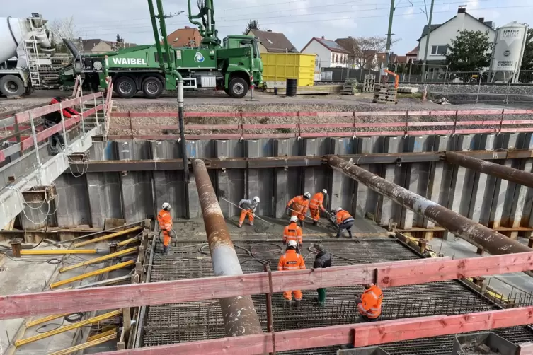 Hand in Hand: Arbeiter betonieren die Trogsohle der künftigen Rampe der Unterführung aus Richtung Westen, während unablässig Fri