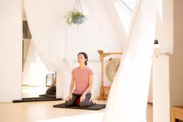 Eine Frau meditiert in einer Yoga-Ecke
