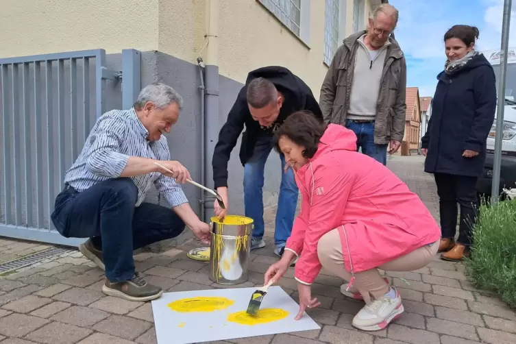 Beim Pinseln: (von links) Hans Schwind, Patrick Poss und Ilona Volk trugen die Farbe auf; im Hintergrund steht die Schulleitung.