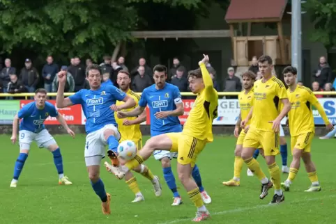 Der Dudenhofener Nik Bauer (gelb) klärt eine Eckballflanke vor Daniel Buballa (blau).