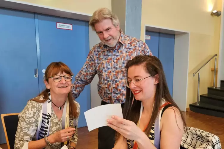 Betrachten Bilder aus einer zum Jubiläum aufgestellten Fotobox: Ellen Eisenbarth-Steinbrecher, Andreas Neu und Cindy Grémy, die 