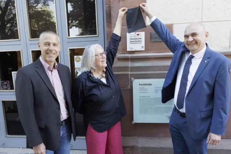  Markus Lang, Ruth Ratter und Manfred Schulz (rechts) enthüllten die Plakette, die die Fruchthalle als „Ort der Demokratiegeschi