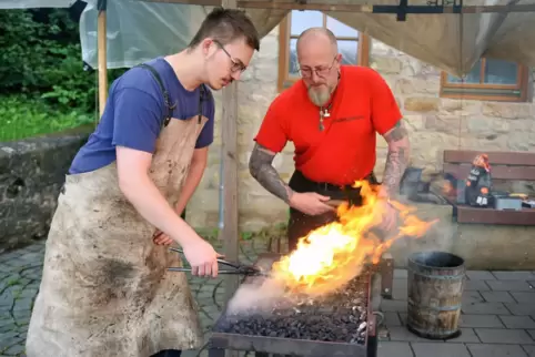 Feuriges Handwerk: Bernd Morgenstern (rechts) hilft dem 19-jährigen Jonas Sperling dabei, ein Messer zu schmieden.