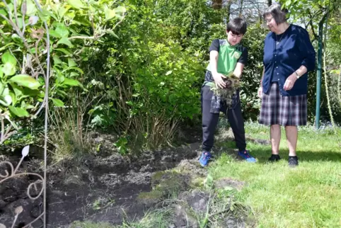 Cahyo Marzen und seine Oma Anne-Marie Marzen aus der Saarbrücker Puccinistraße demonstrieren mit einem Erdhaufen, wie schlimm di