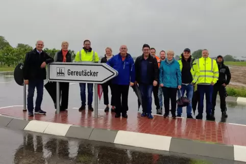 Gruppenbild mit Wegweiser. Von der neuen Straße erhofft man sich Verkehrsentlastung und vom Gewerbegebiet Arbeitsplätze. 