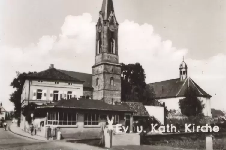 Das gemischte Ensemble von protestantischem Pfarrhaus, Kirchturm, beiden Kirchen und dem Stellwerk im Vordergrund auf einer Ansi