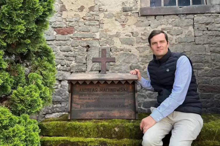 Ludwig von Heyl mit der Gedenktafel für den 1942 hingerichteten Andreas Machowski. Auf dem frisch restaurierten Holz ist der Nam