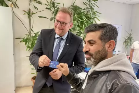 Morad Muhsen aus Syrien (rechts) erhält von Oberbürgermeister Markus Zwick die erste Bezahlkarte. 