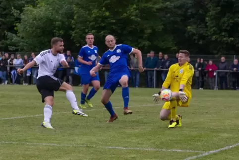  Torwart Eric Wambach (gelbes Trikot) vom SV Brücken hält den Schuss von Julian Uhlhorn (links) von der SG Bechhofen/Lambsborn. 