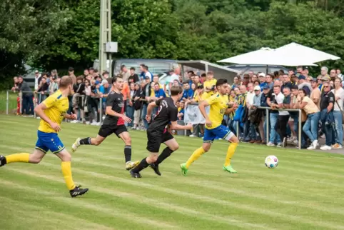  Der Freimersheimer Joshua Moos treibt den Ball, Tim Dubois und Mirko Werling bleiben an ihm dran. Links David Müssig.