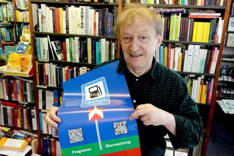 Franz-Josef „Morphy“ Burkhardt mit dem Plakat samtn QR-Codes zum Festival „Lautern liest“ in seiner Buchhandlung Blaue Blume. De