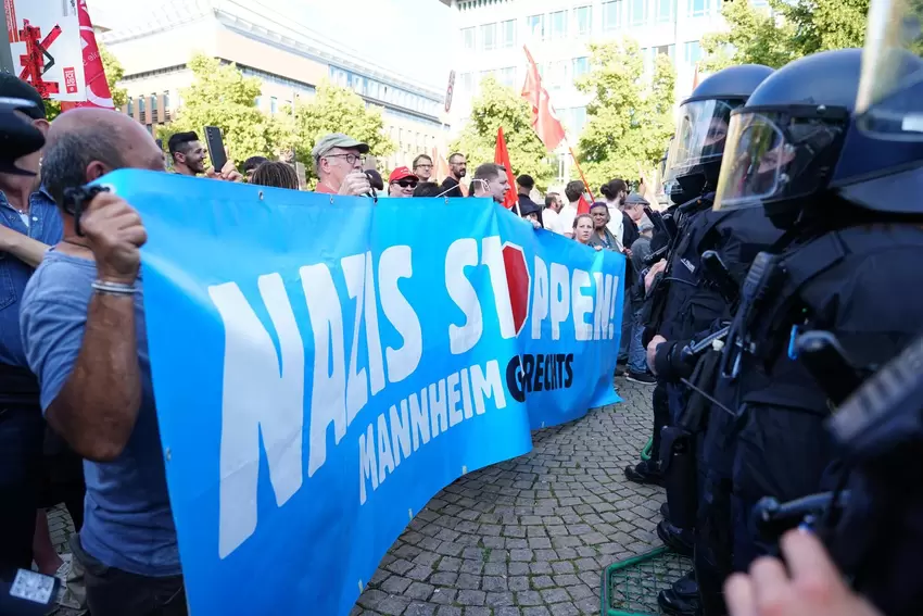 Am Paradeplatz halten Bereitschaftspolizisten in Schutzmontur Gegendemonstranten und Teilnehmer der AfD-Kundgebung auseinander.