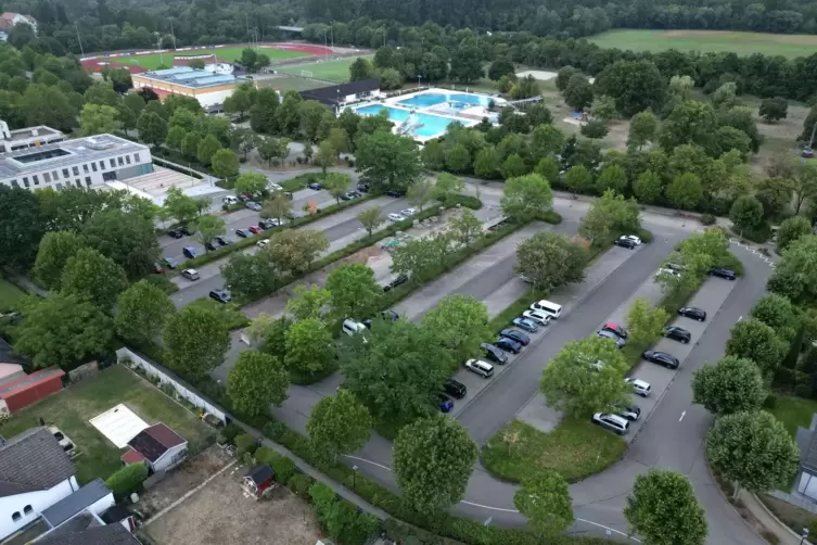 Der Parkplatz am Konrad-Lerch-Ring aus der Vogelperspektive. Links das neue Rathaus, im Hintergrund das Queichtalbad.