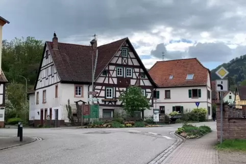 Die Ortsstraße in Rumbach heute: An der Grünfläche mit Holzschuhen ist heute der Treffpunkt „an de Brigg“.