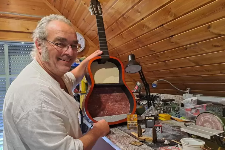 Hännes in seiner kleinen Werkstatt mit einer alten Gitarre, die er mit Leben füllen will. 