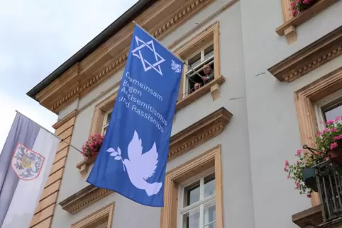 Oberbürgermeister Dominik Geißler (r.) und Hausmeister Gernot Cadorin beim Hängen der Flagge gegen Antisemitismus und Rassismus 